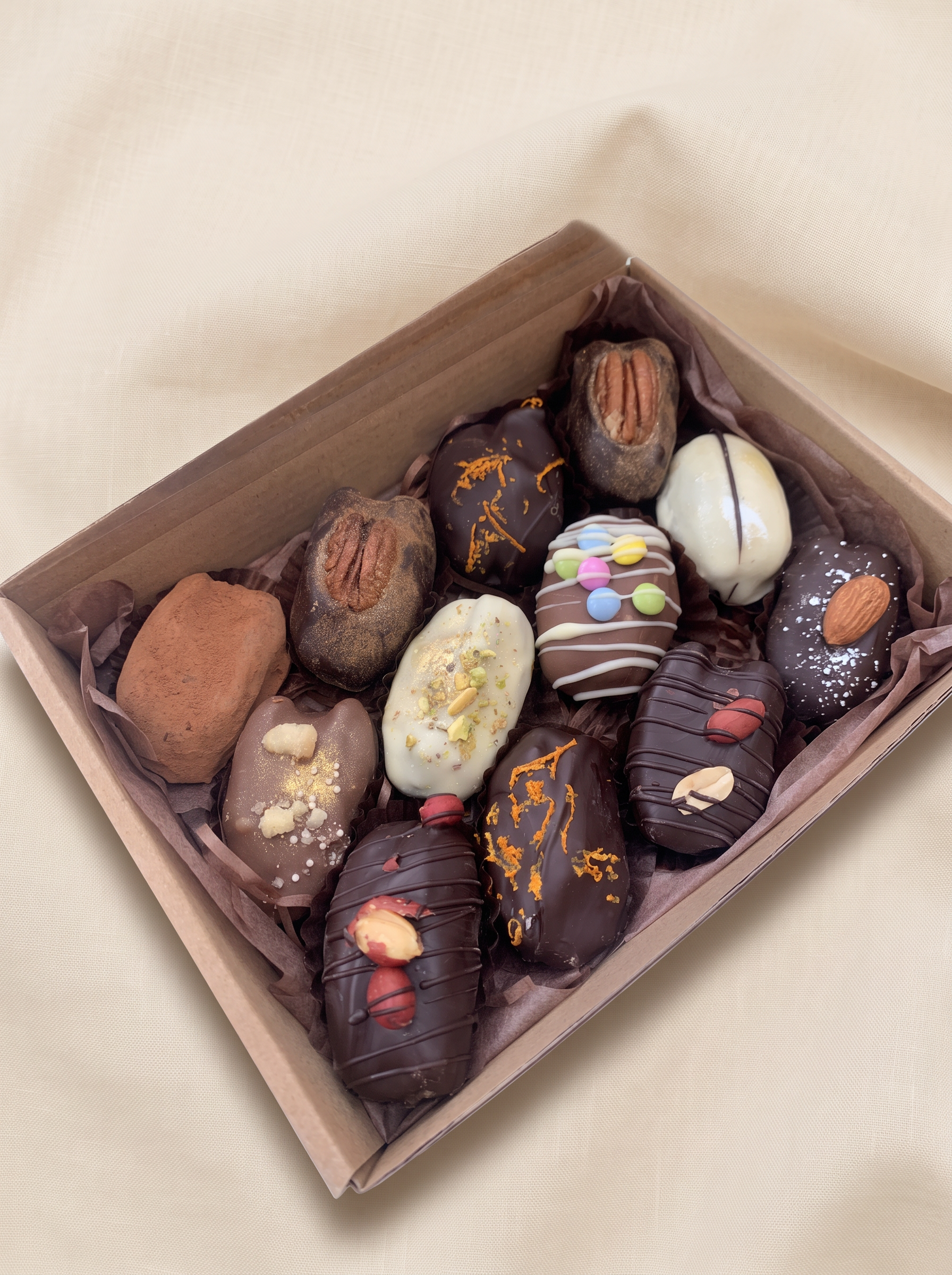 Chocolate coated medjool dates topped with nuts and drizzle